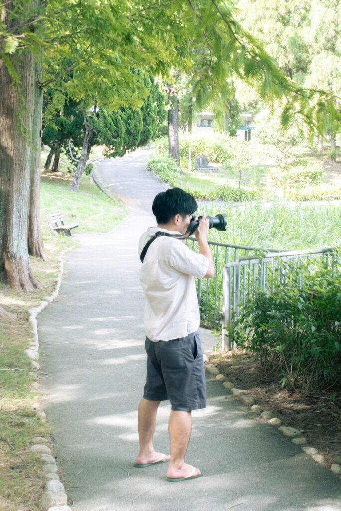 Nikon Z6IIIにNIKKOR 24-120mm F4をつけたカメラを構える男性の写真
