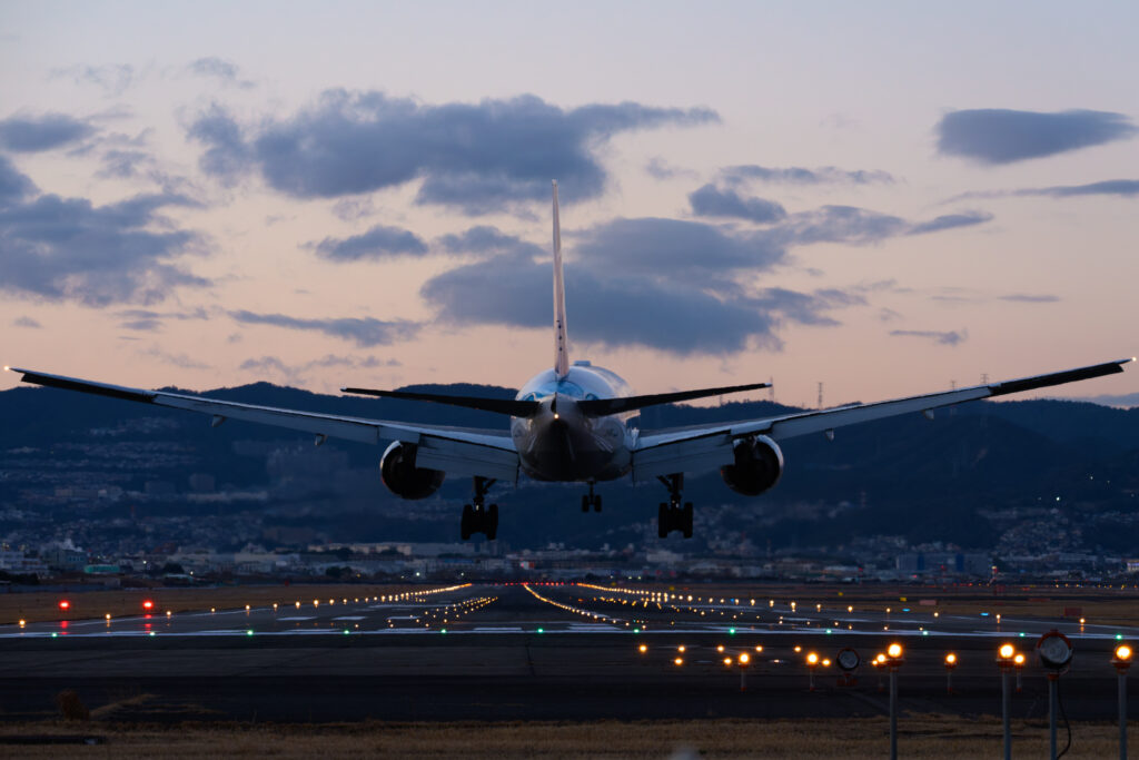 夕暮れ時に伊丹空港に着陸する飛行機を撮影した画像